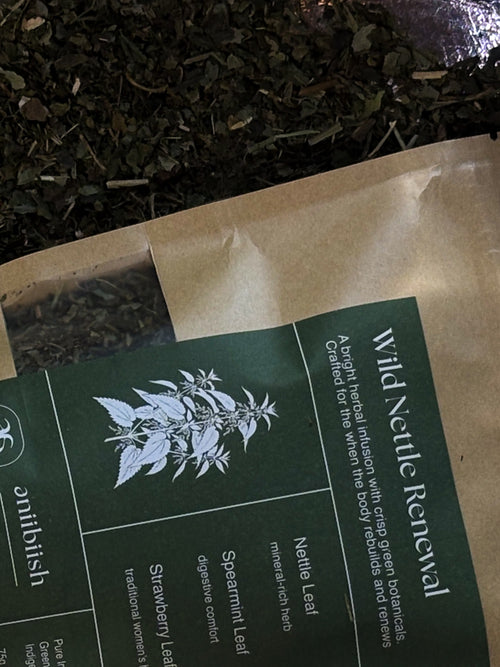 Tea packaging with 'Wild Nettle Renewal' label and tea leaves in the background