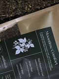 Tea packaging with 'Moontime Comfort' label and herbal illustration on a dark background.