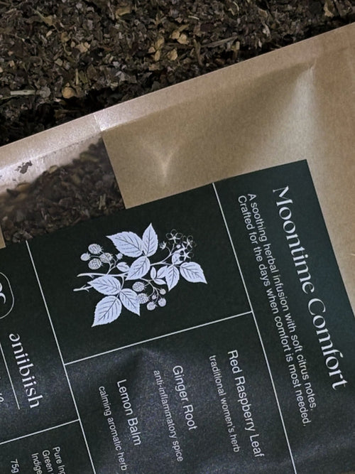Tea packaging with 'Moontime Comfort' label and herbal illustration on a dark background.